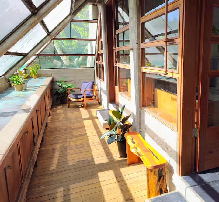 sunroom ideas with an angled glass roof and warm wood cabinetry