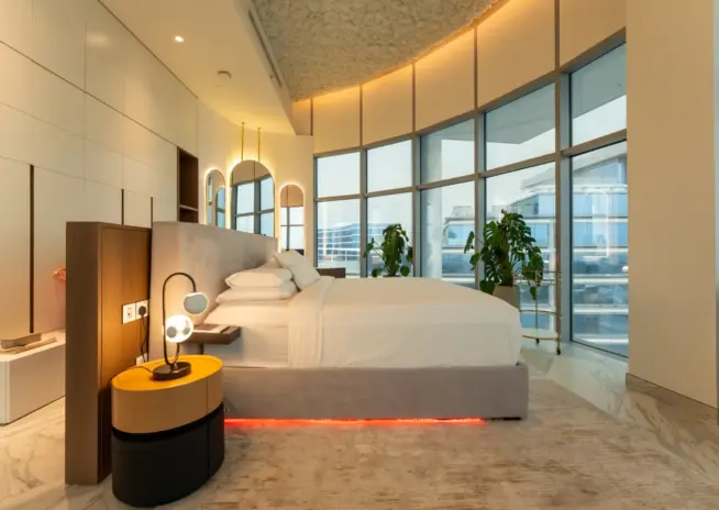 bedroom with a curved bed and warm under bed lighting
