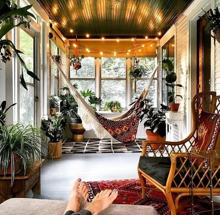 cozy sunroom ideas in a bohemian style with a hammock and string lights