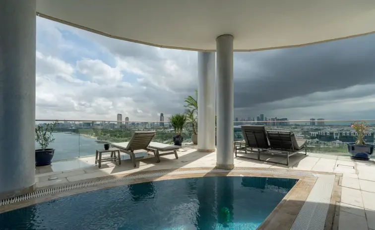 rooftop pool terrace with sun loungers and a water view