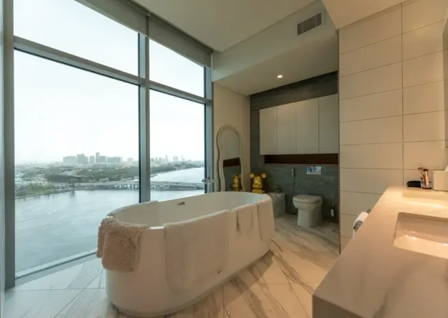 bathroom with a freestanding tub facing a city view