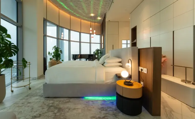 bedroom with a curved bed and a glowing bedside table