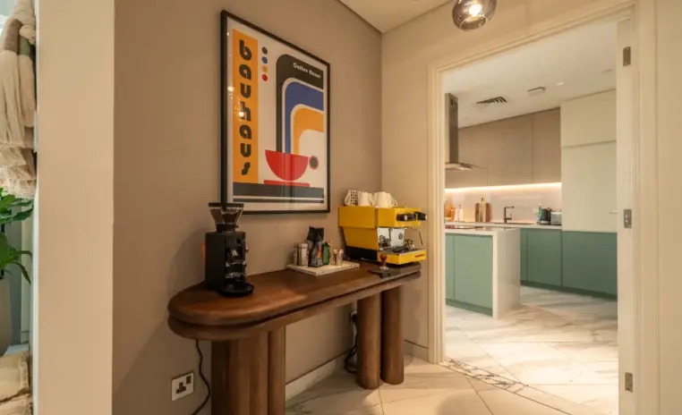 coffee station on a wooden console beside a kitchen