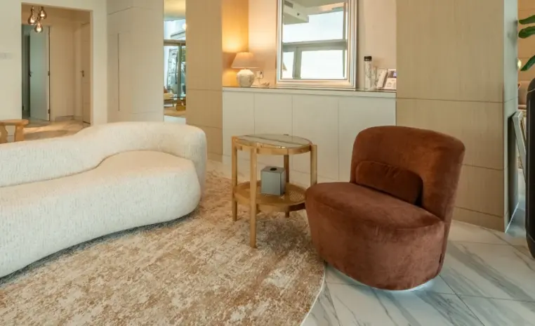bedroom seating area with a brown armchair and a curved sofa