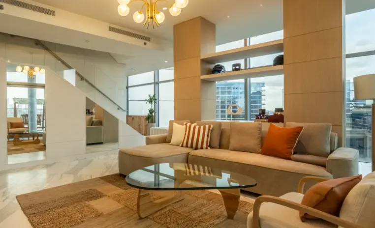 double height living room with layered seating and tall windows