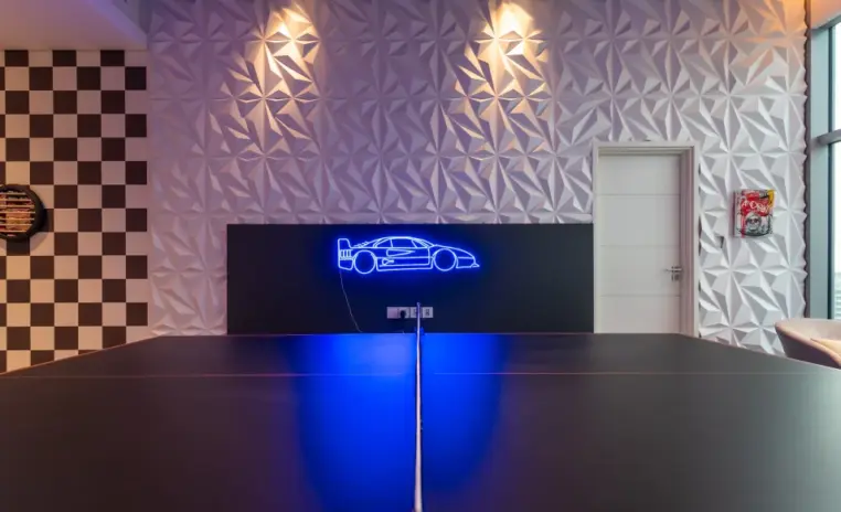 games room with a neon car artwork and a checkerboard wall