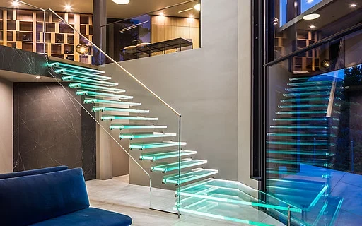 glass panel stair railing opening up a narrow staircase in a small home