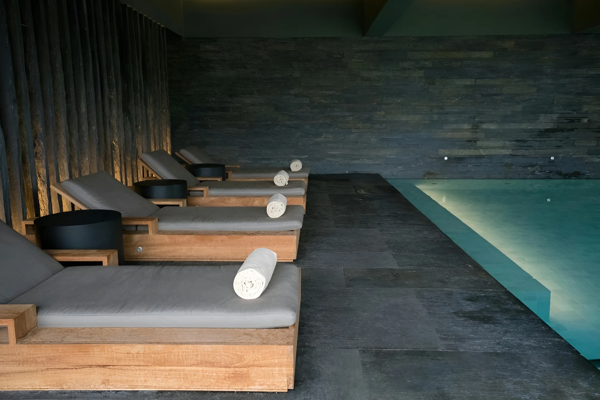 hotel spa with stone loungers beside a lap pool spa interior design service in dubai