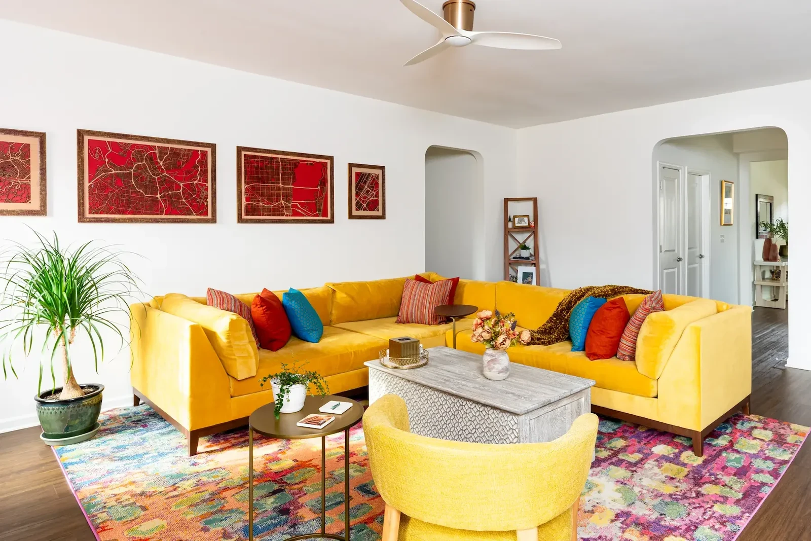 bright living room ideas with a yellow sectional sofa and colourful patterned rug