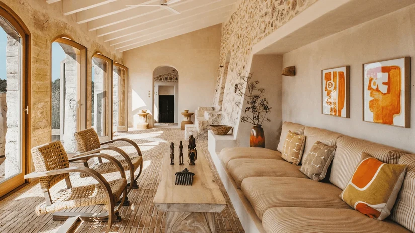 traditional mediterranean interior style lounge with exposed beams and a stone wall
